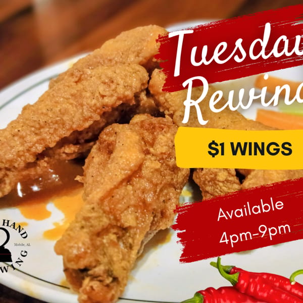 Crispy fried chicken wings on a white plate with celery and carrots, advertising $1 wings.