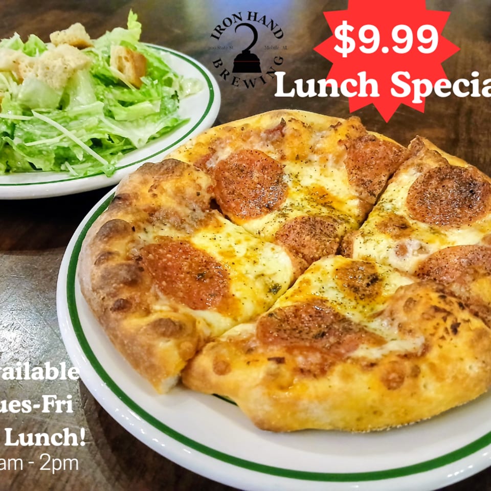 Pepperoni pizza and a side salad on a wooden table, advertising Iron Hand Brewing's lunch specials.